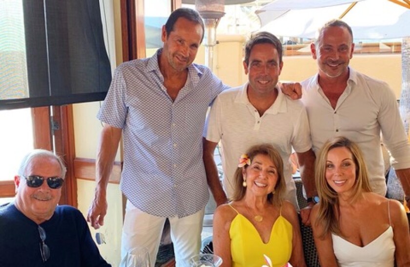 ジム・ウッデン氏は妻のカーリーン氏(中央)と共に、(左から)グレッグ、ジョン、マイケル、キムという子供たちと一緒に座っている。