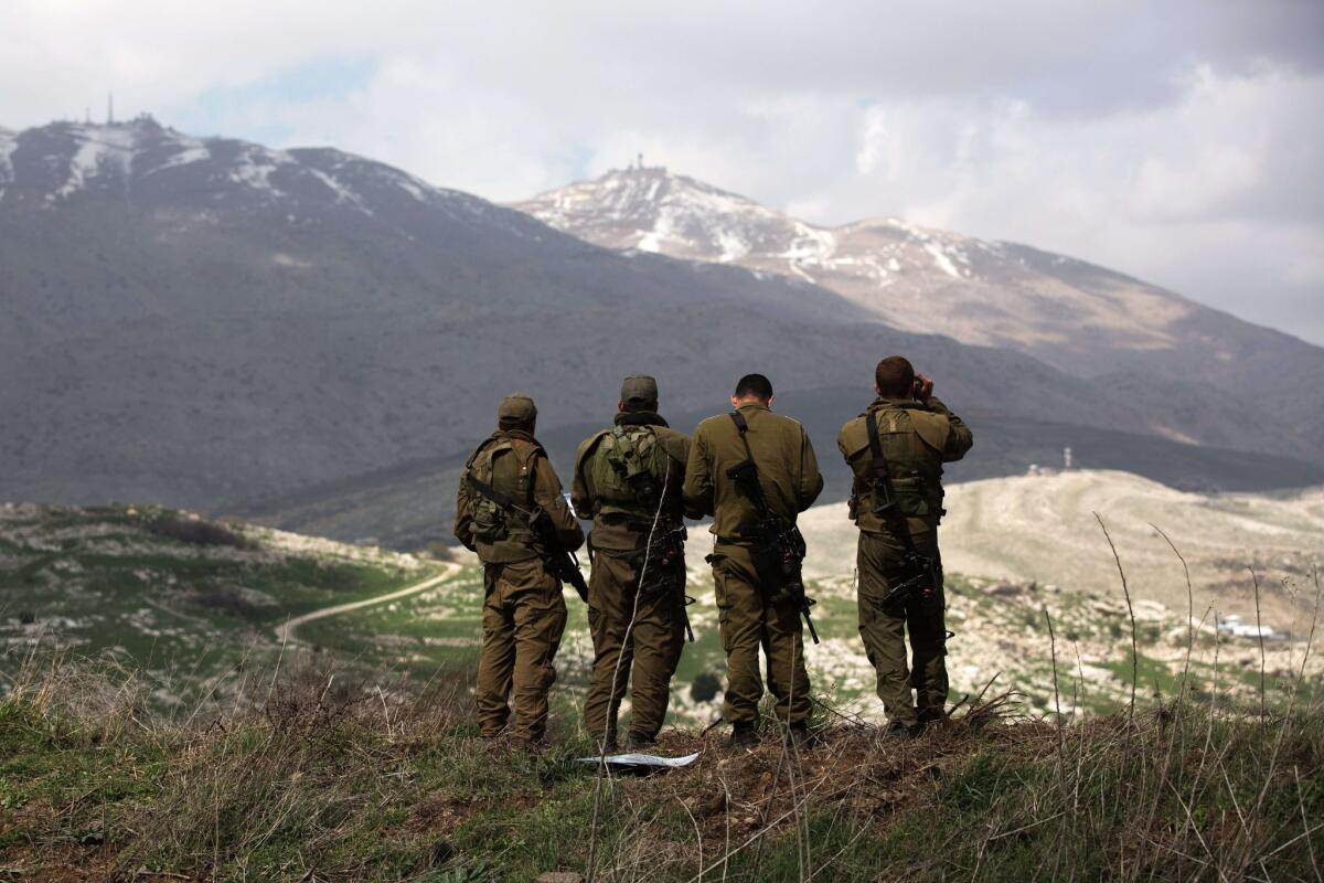 Israeli soldiers deployed on the Golan Heights observe Syrian territory from near the Druze village of Majdal Shams on Wednesday.