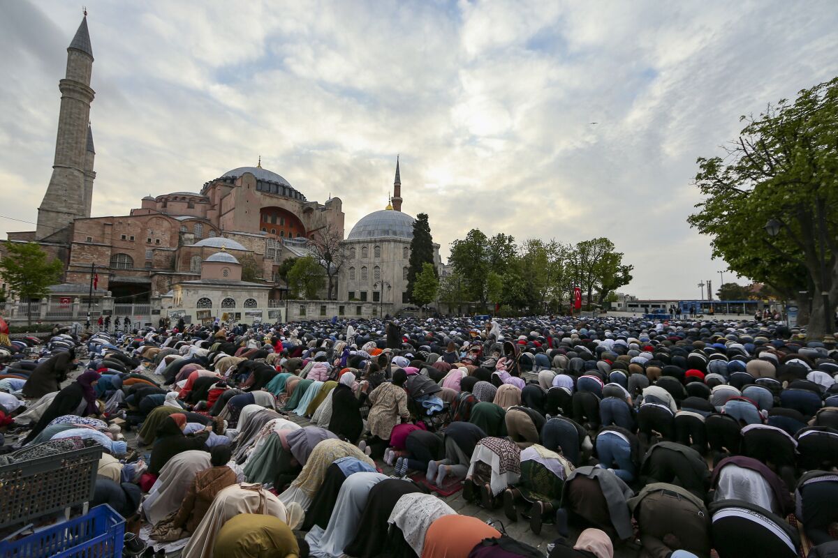 Muslims offer prayers during the first day of Eid al-Fitr, which marks the end of the holy month of Ramadan outside the iconic-historic Haghia Sophia Mosque in Istanbul, Turkey, Monday, May 2, 2022. (AP Photo/Emrah Gurel)
