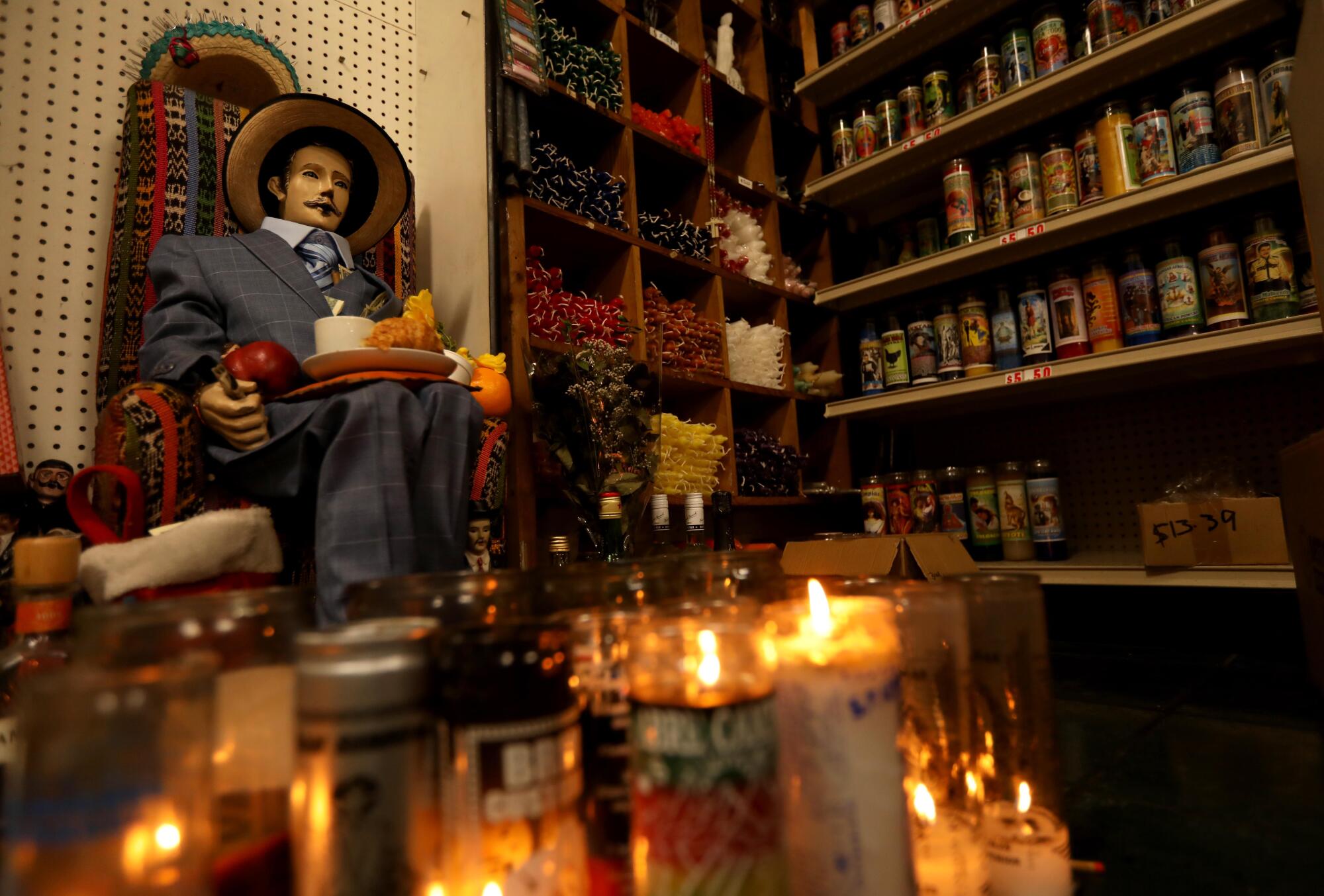 A display including candles and San Simon .