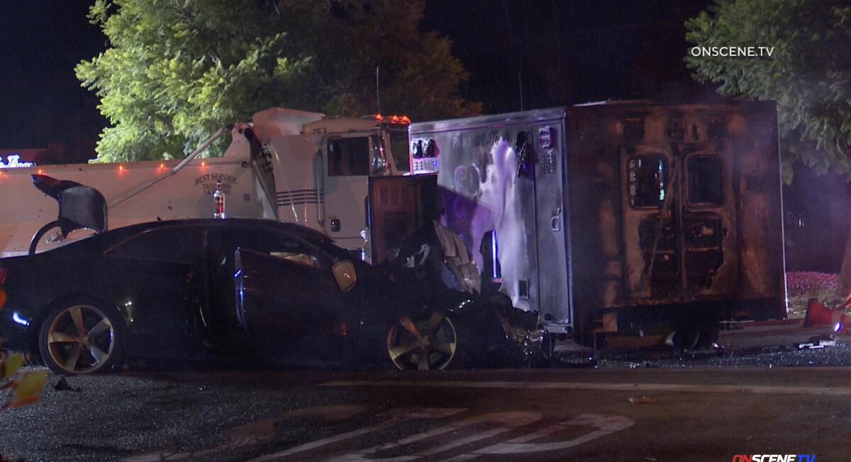 A car next to a truck and a smoke-blackened ambulance.