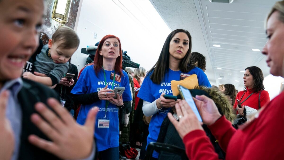 Activists opposed to mandatory vaccinations gather outside a Senate committee hearing on the issue in Washington.