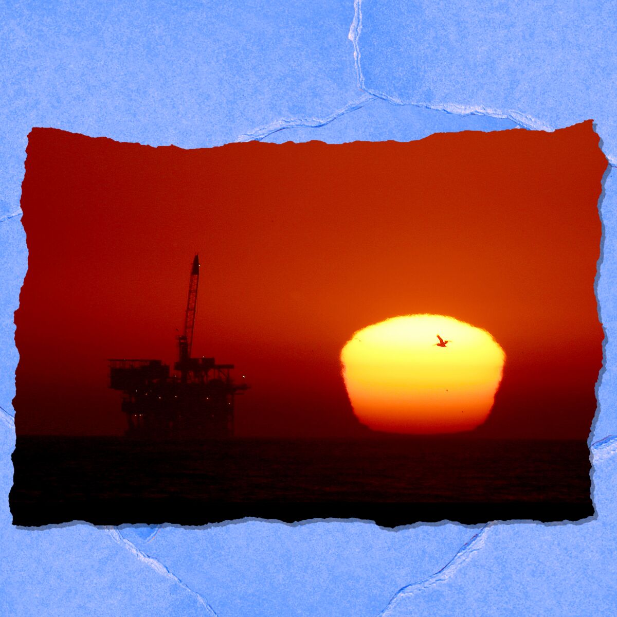 An oil rig is seen against a red sky as the sun sets.