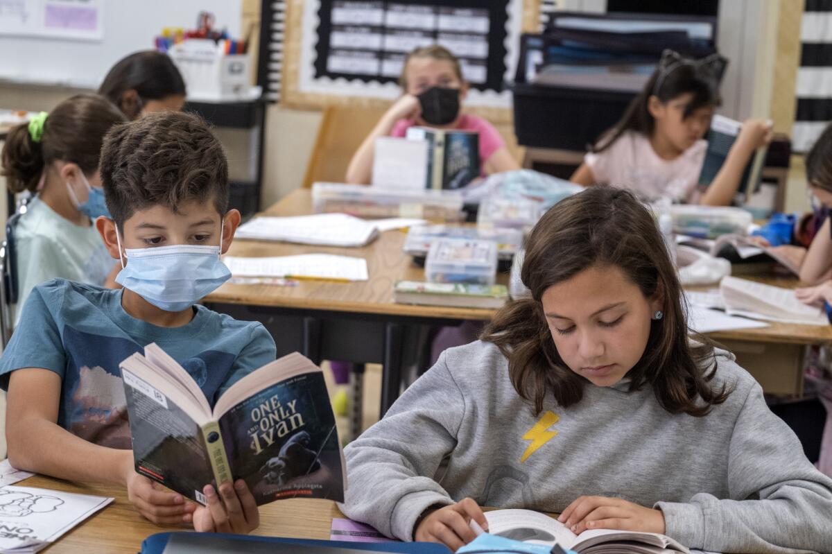 Elementary school students read at a table.