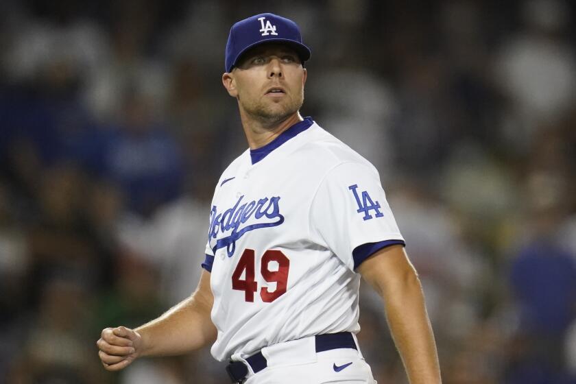 Los Angeles Dodgers relief pitcher Blake Treinen (49) watches as a foul ball flies.