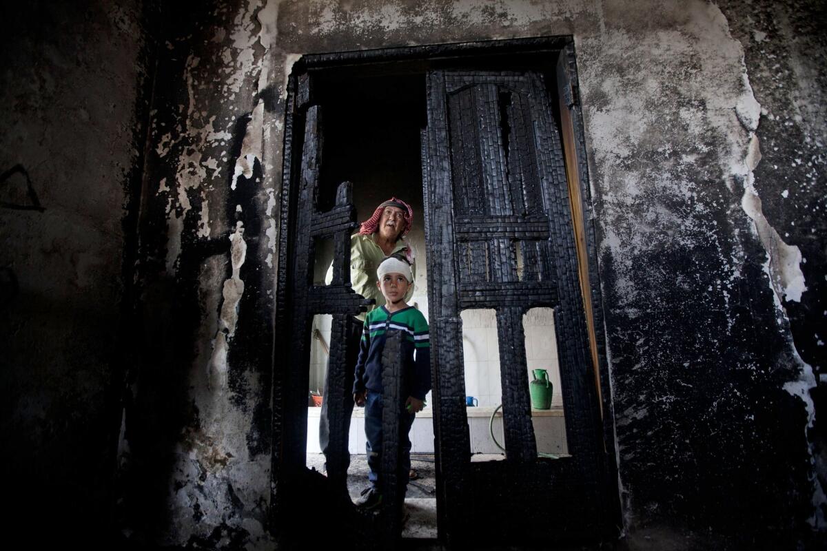 Palestinians inspect damage from a fire at a mosque in the West Bank village of Mughayer on Nov. 12.