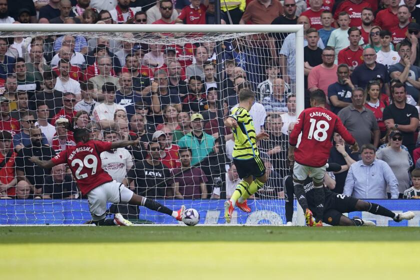 Arsenal's Leandro Trossard, centre, scores his side's opening goal during the English Premier League soccer match between Manchester United and Arsenal at the Old Trafford Stadium in Manchester, England, Sunday, May 12, 2024. (AP Photo/Dave Thompson)