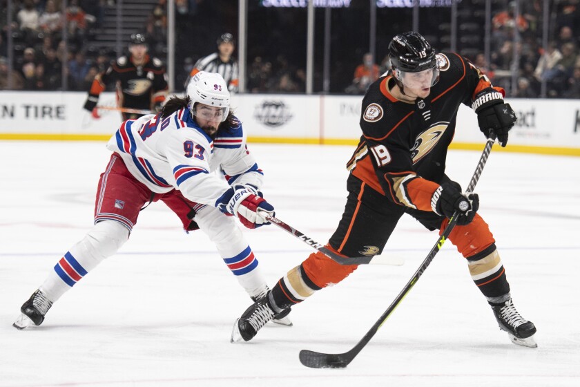 Anaheim Ducks right wing Troy Terry (19) shoots as New York Rangers center Mika Zibanejad (93) defends during the second period of an NHL hockey game in Anaheim, Calif., Saturday, Jan. 8, 2022. (AP Photo/Kyusung Gong)