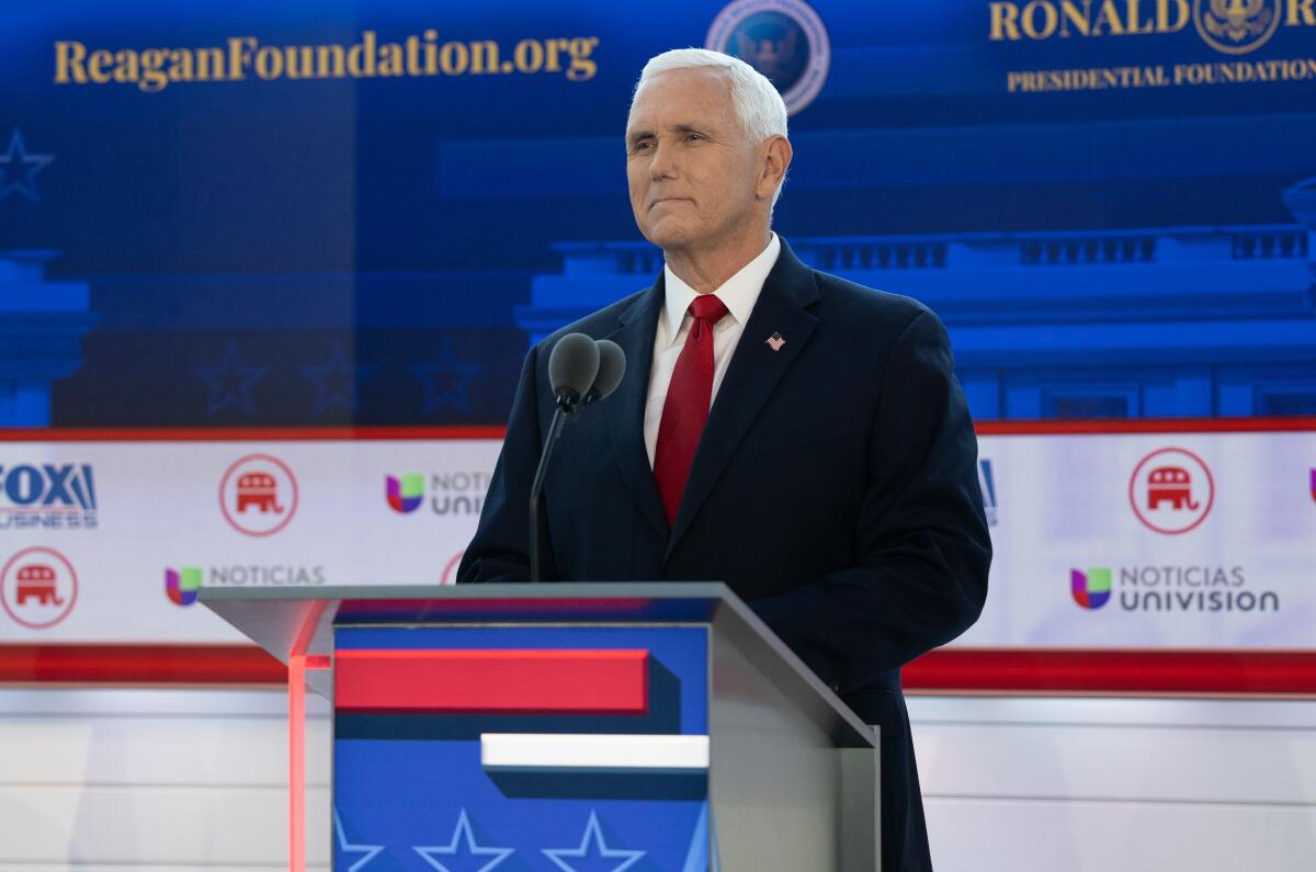 Mike Pence standing at a lectern against a red, white and blue backdrop reading "ReaganFoundation.org" above TV and GOP logos