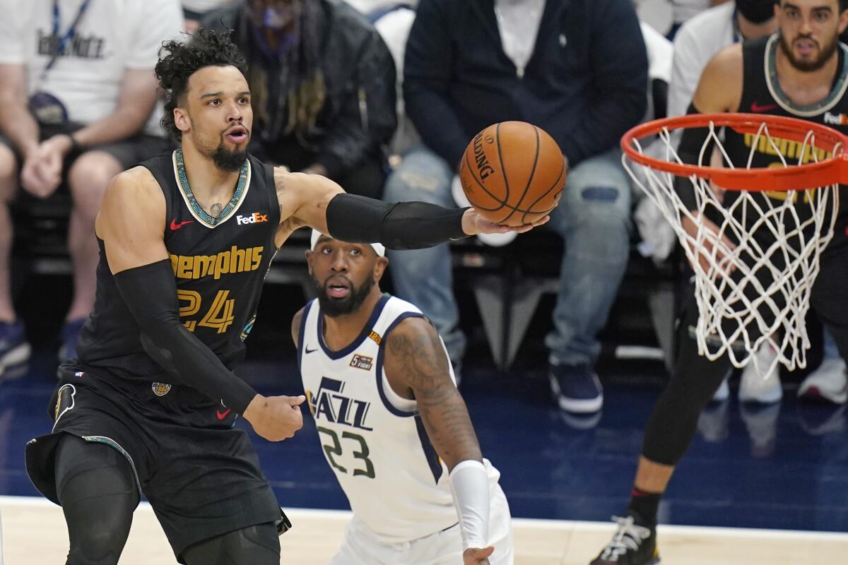 Grizzlies forward Dillon Brooks scores on a layup while defended by Jazz forward Royce O'Neale.