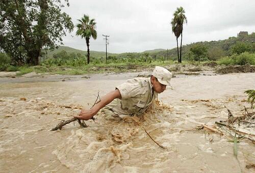 A Mexican soldiers works to clear a road in Todos Santos, Mexico.