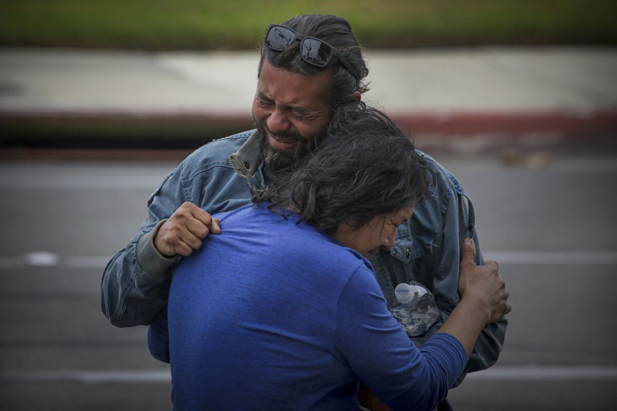 Sergio Marroquin and a family member grasp each other in grief at the crash site Thursday.