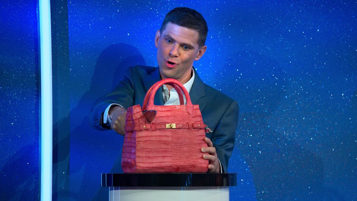 A man slices into a cake that looks like a pink purse.