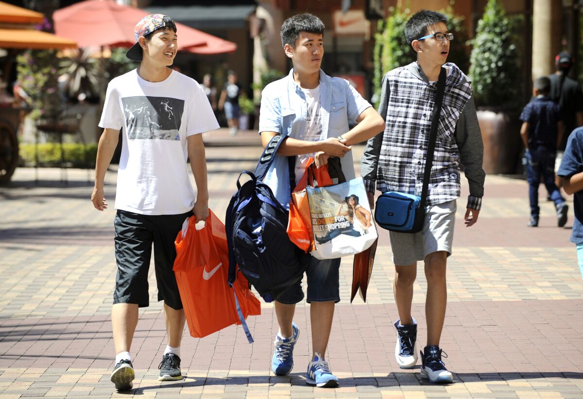 Chinese tourists shop at the Citadel Outlets in Commerce on Aug. 12, 2015. Spending by international travelers to California has leveled off because of the drop in value of foreign currency compared with the U.S. dollar.