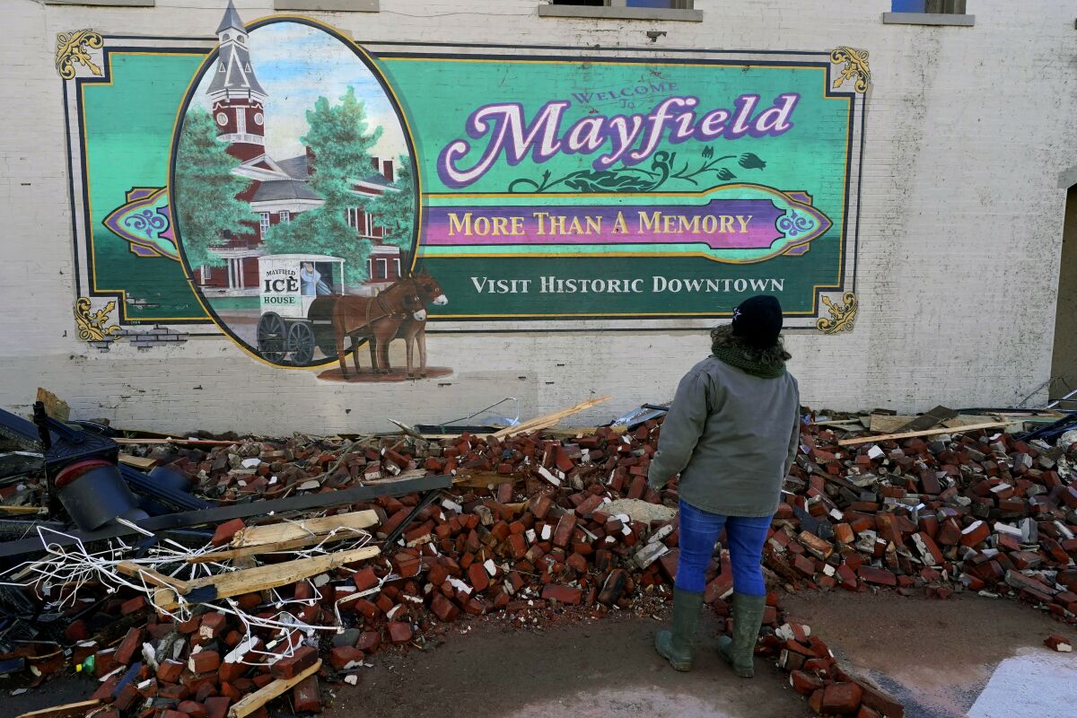 Damage from a tornado is seen by a "Welcome to Mayfield" sign