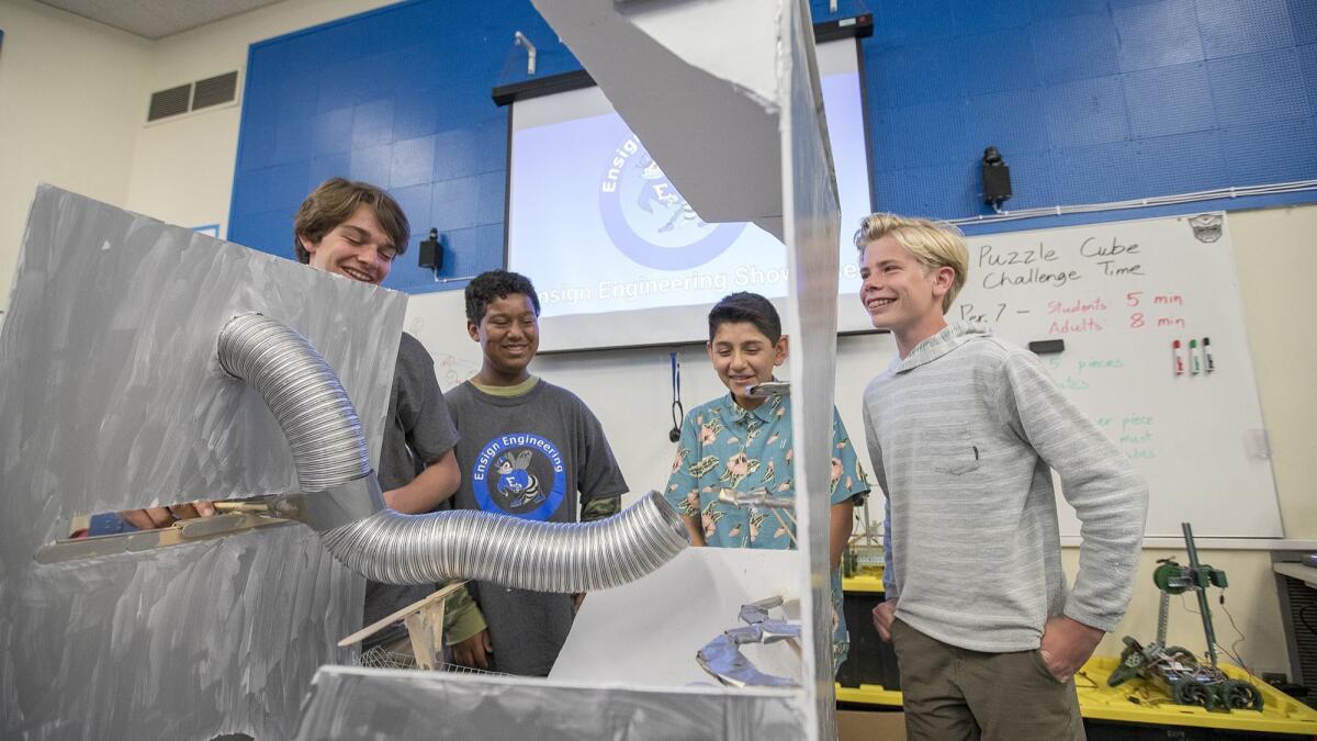 Rehn Palmquist, 13, Ichiro Williams, 12, Jorge Ramirez, 13, and Tommy Robinson, 13, from left, demonstrate Golden Hoops, a toy they created for children with cerebral palsy, during Ensign Intermediate School’s engineering showcase Wednesday.