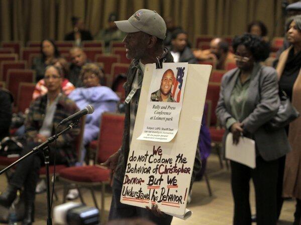 Community activist Morris Griffin holds a sign that echoed sentiments among some audience members at a meeting with L.A. Police Chief Charlie Beck. The Southern California Cease Fire Committee hosted the forum with Beck to address South L.A. residents' concerns about the LAPD and the late Christopher Dorner's manifesto, which blamed his firing from the department on racists and liars.