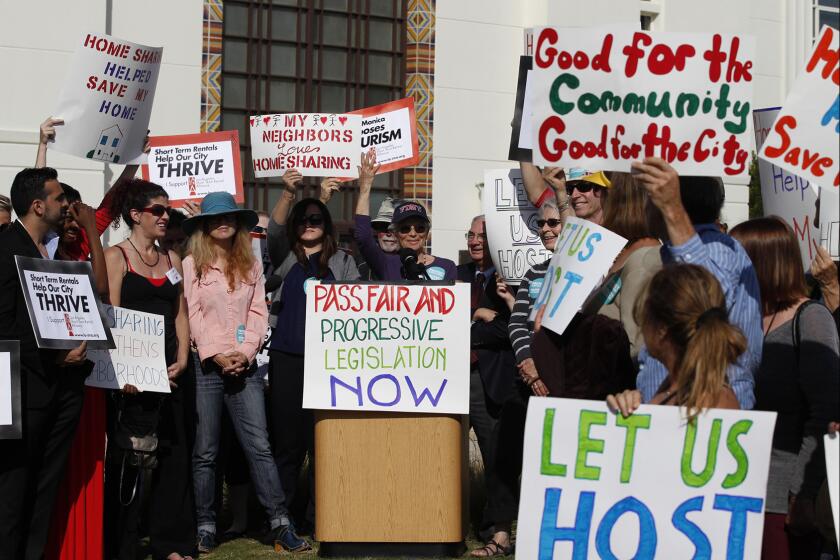 Airbnb supporters listen to Airbnb host Arlene Rosenblatt speak during a rally outside the Santa Monica City Council as they are set for a second and final vote on regulations that would outlaw most short-term rentals in the beach city.