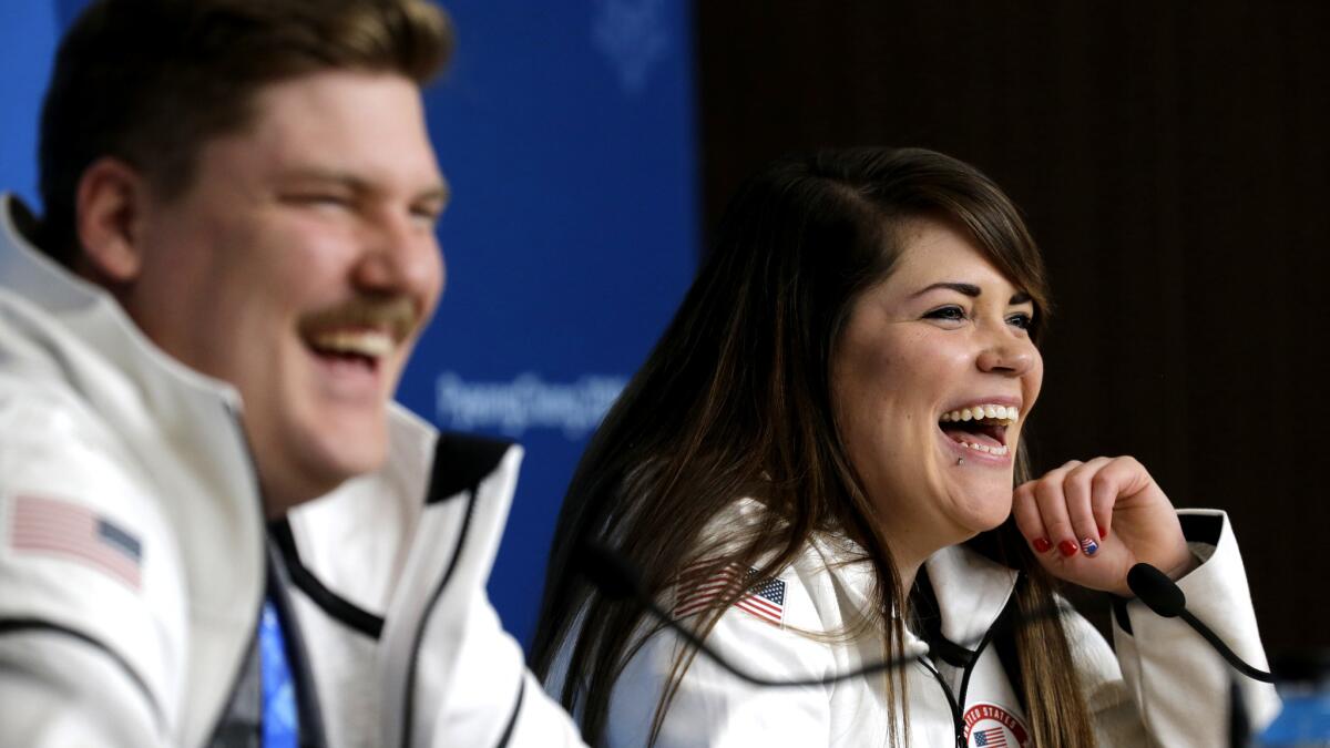 Matt and Becca Hamilton share a laugh with reporters during a news conference before the Winter Olympics.