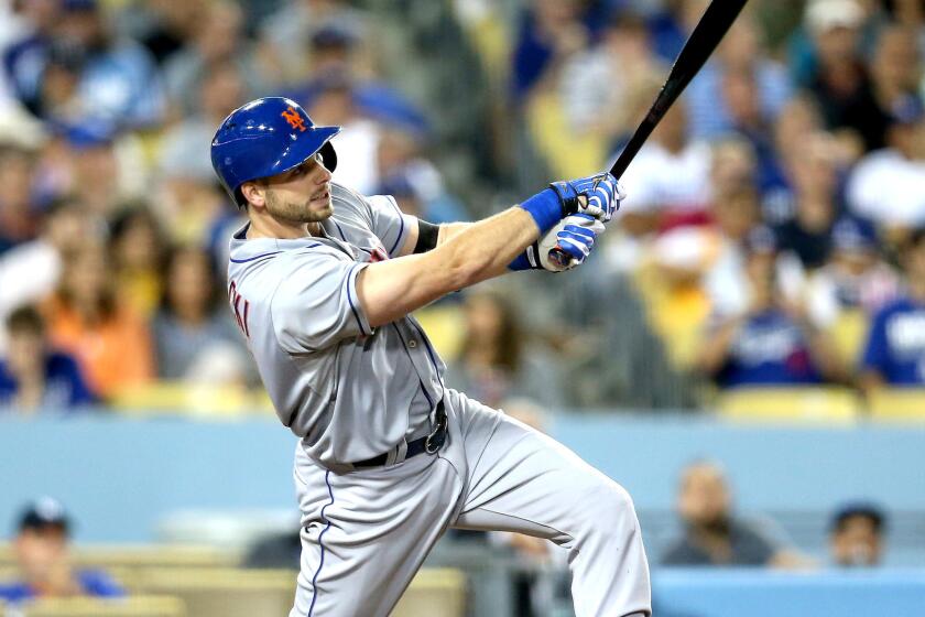 Mets catcher Kevin Plawecki delivers a sacrifice fly to deep center field against the Dodgers to score the winning run in the ninth inning Friday night at Dodger Stadium.