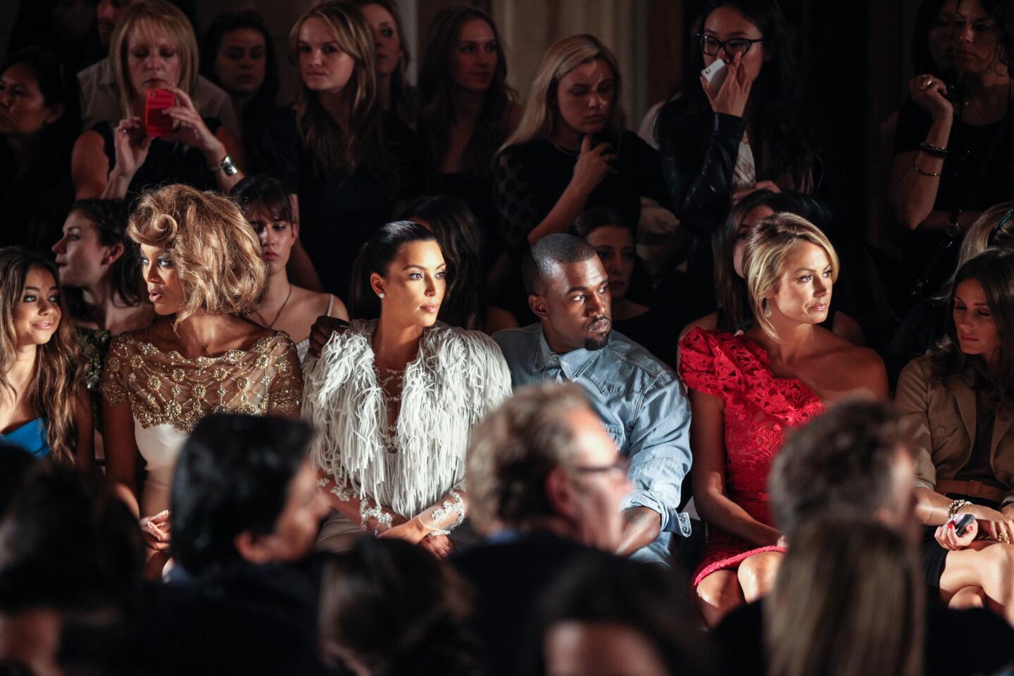Actress Sarah Hyland, left, model Tyra Banks, television personality Kim Kardashian, rapper Kanye West, actress Stacy Keibler and television personality Olivia Palermo attend the Marchesa show during New York Fashion Week on Sept. 12, 2012.