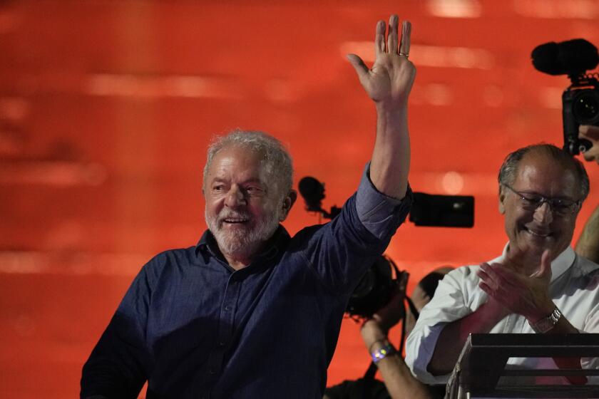 Former Brazilian President Luiz Inacio Lula waves to supporters gathered on Paulista Av. after he defeated incumbent Jair Bolsonaro in a presidential run-off election to become the country's next president, in Sao Paulo, Brazil, Sunday, Oct. 30, 2022. At right is running mate Geraldo Alckmin. (AP Photo/Andre Penner)