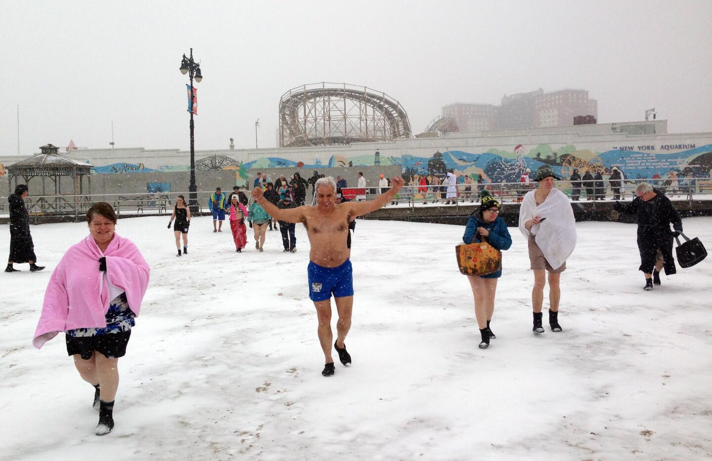 Louis Padilla, in blue swim trunks, and other members of the Coney Island Polar Bear Club in New York walk through the snow toward the water for their weekly winter swim. The 112-year-old club meets each Sunday from November until April for a dunk, which members swear is good for their health.