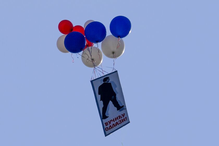 Balloons with a photo of Serbian President Aleksandar vucic that reads: 'Vucic go away!" fly during a protest against violence in Belgrade, Serbia, Saturday, June 3, 2023. Tens of thousands of people rallied in Serbia's capital on Saturday in protest of the government's handling of a crisis after two mass shootings in the Balkan country. (AP Photo/Darko Vojinovic)