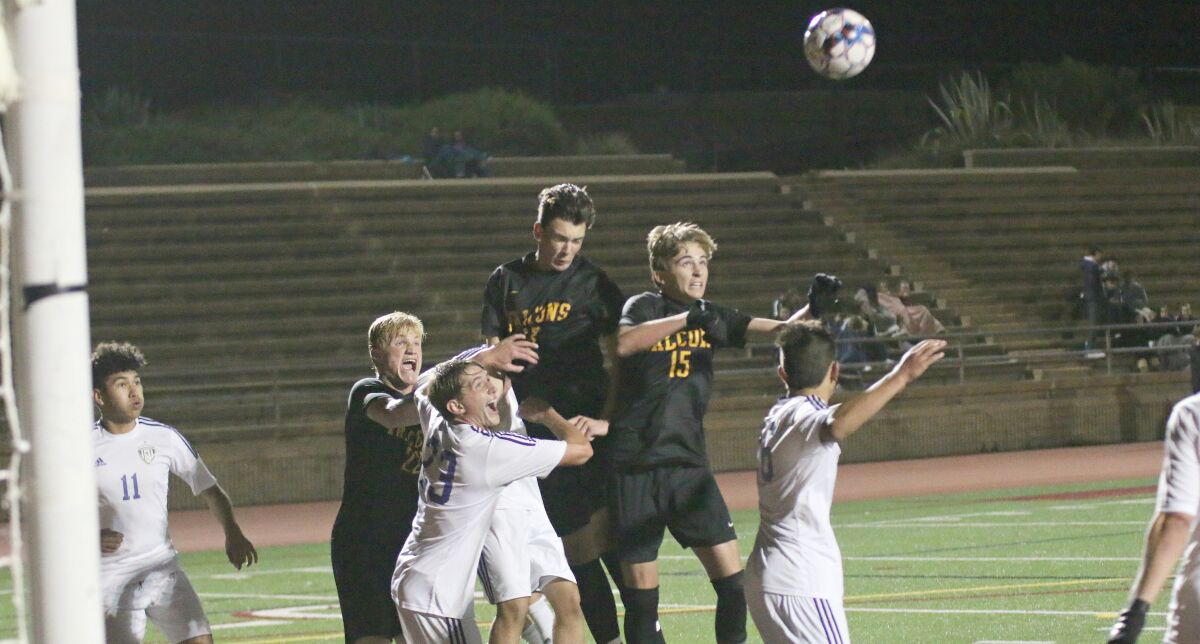 The Falcons' Zach Lesher (#15) targets a header.