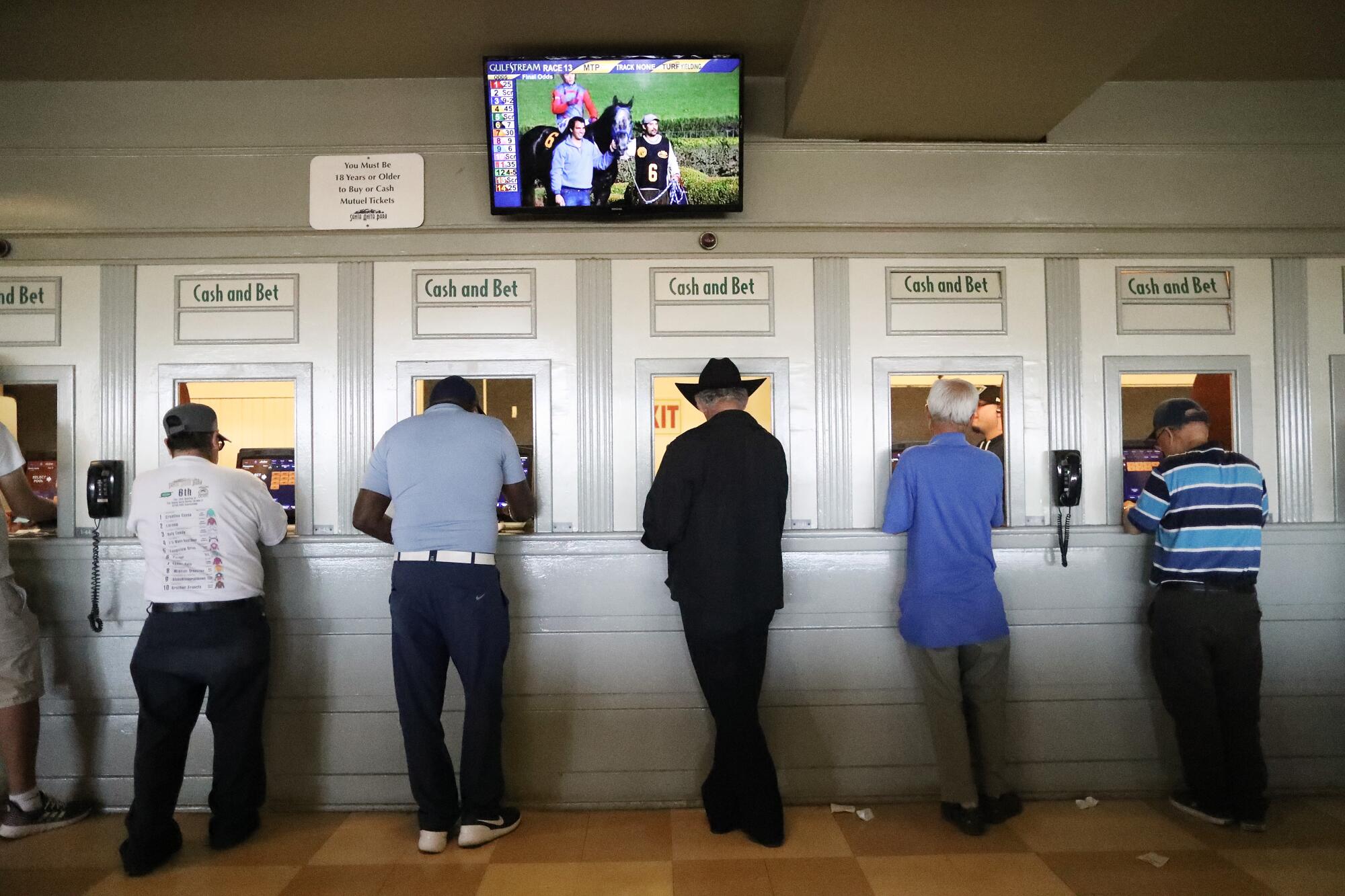 Gamblers make their wagers at Santa Anita Park's betting windows on the final day of the 2019 winter/spring meet.
