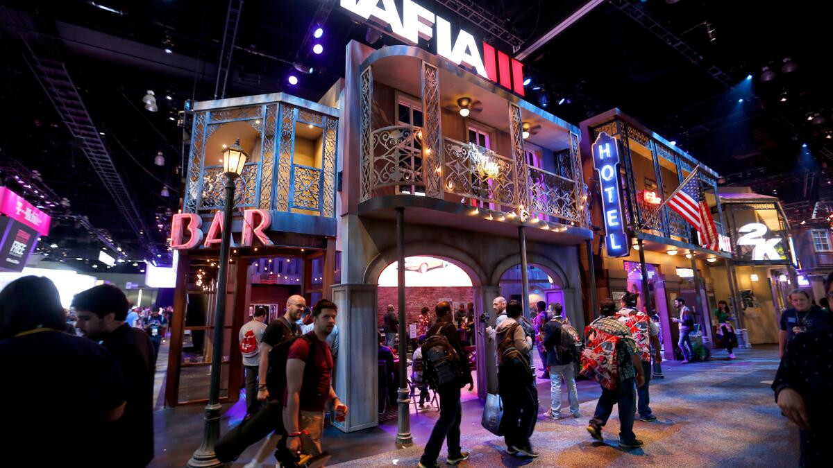 A crowd walks by the elaborate set for the Mafia III video game during the Electronic Entertainment Expo in June at the Los Angeles Convention Center.