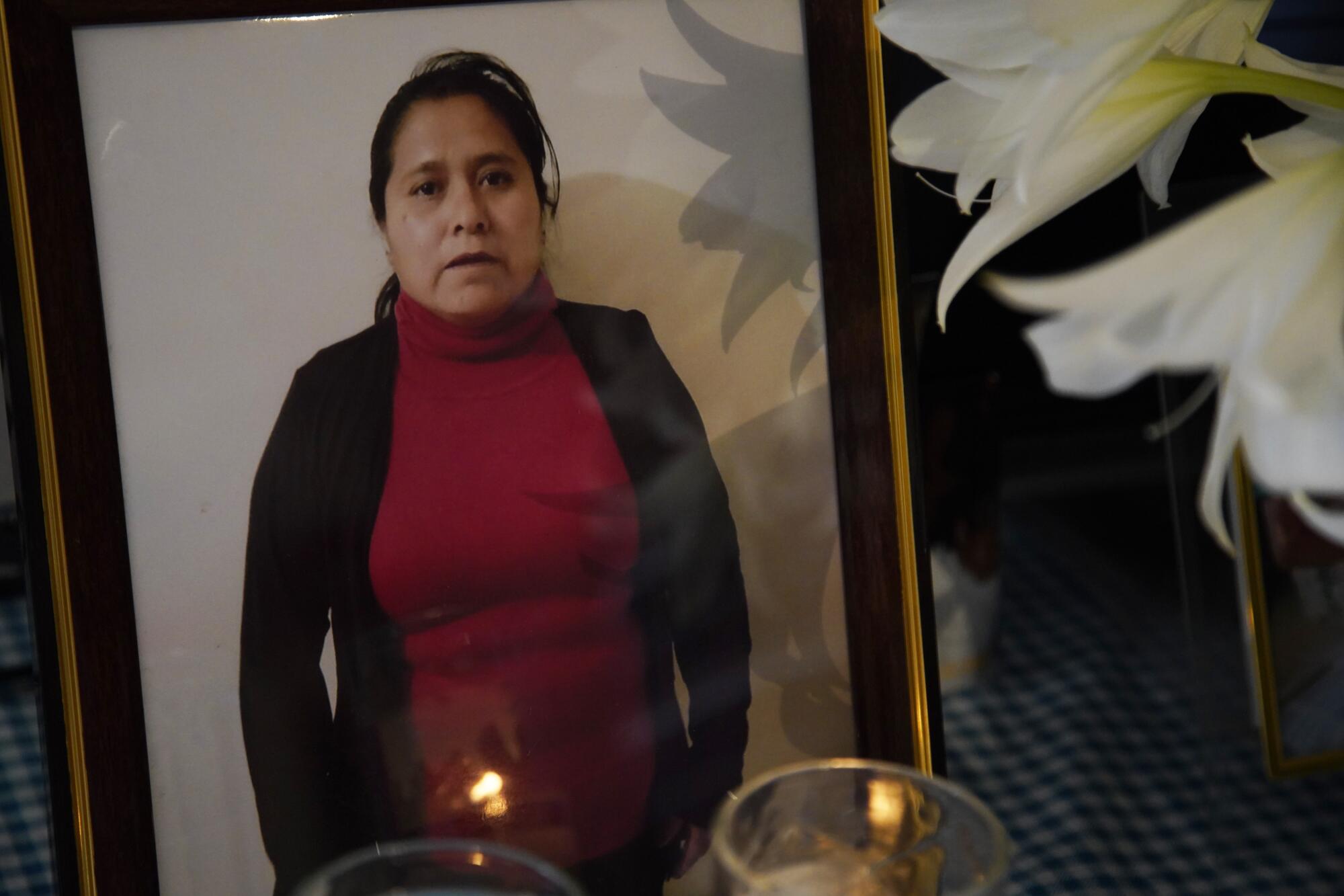 Photo of a woman with votive candles in front of it.