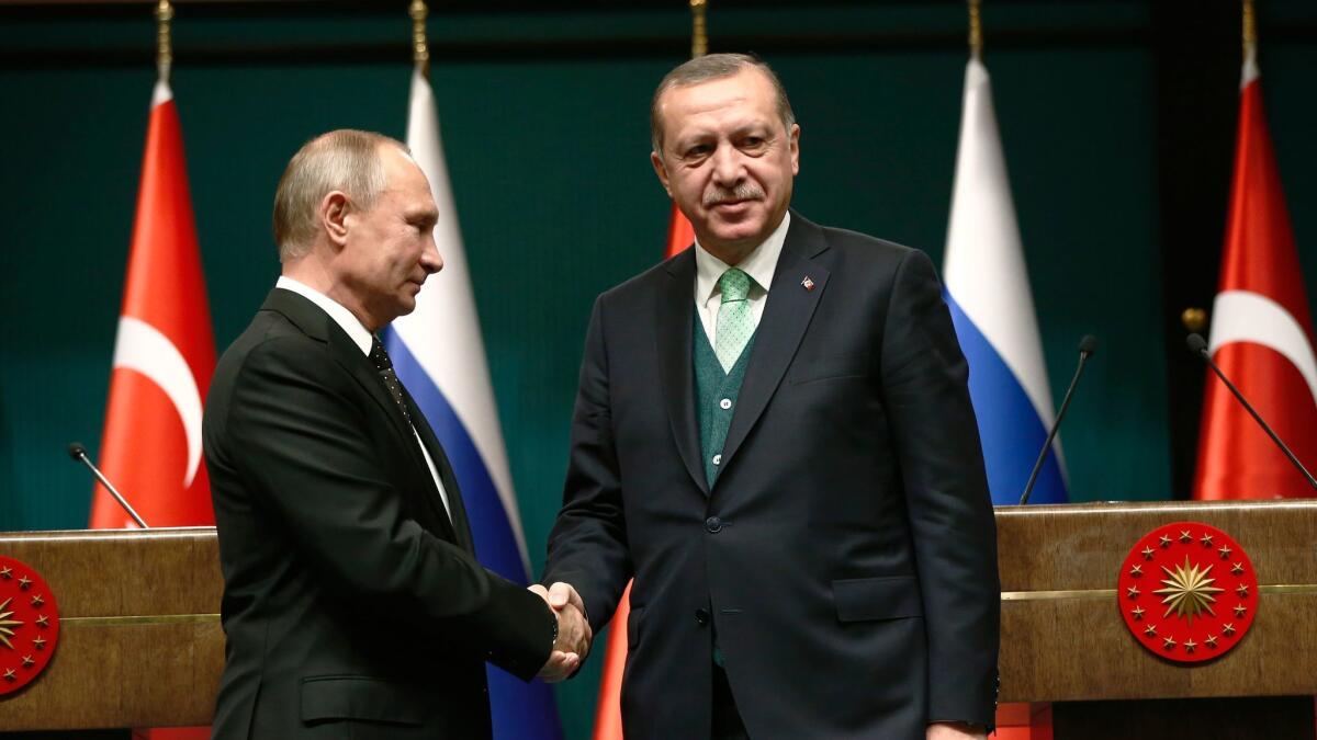 Turkey's President Recep Tayyip Erdogan, right, shakes hands with Russia's President Vladimir Putin following their joint news statement after their meeting at the Presidential Palace in Ankara, Turkey, on Dec. 11.