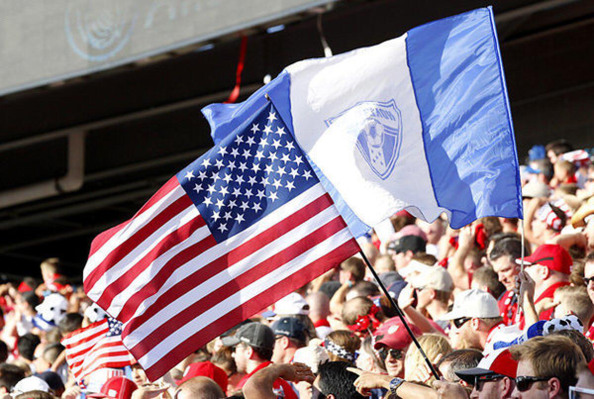 Fans of the United States and Honduras fly flags from each country during the first half of the World Cup qualifying match.