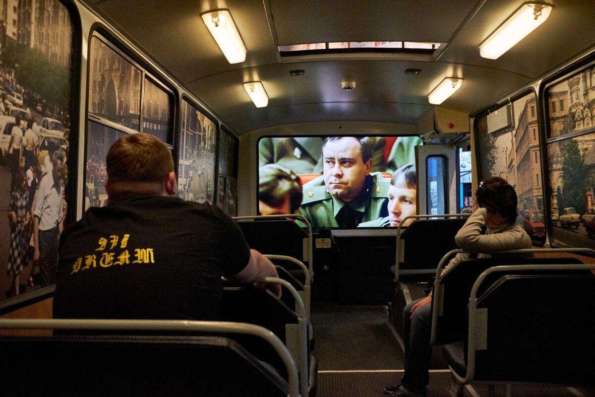 Visitors sit in a bus installed in one of the Boris Yeltsin Museum's exhibition halls dedicated to the August 1991 coup d'etat attempt.