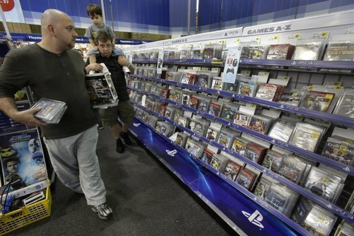 Holiday-season shoppers look for bargains in the video game section of a Best Buy store in Orlando, Fla.
