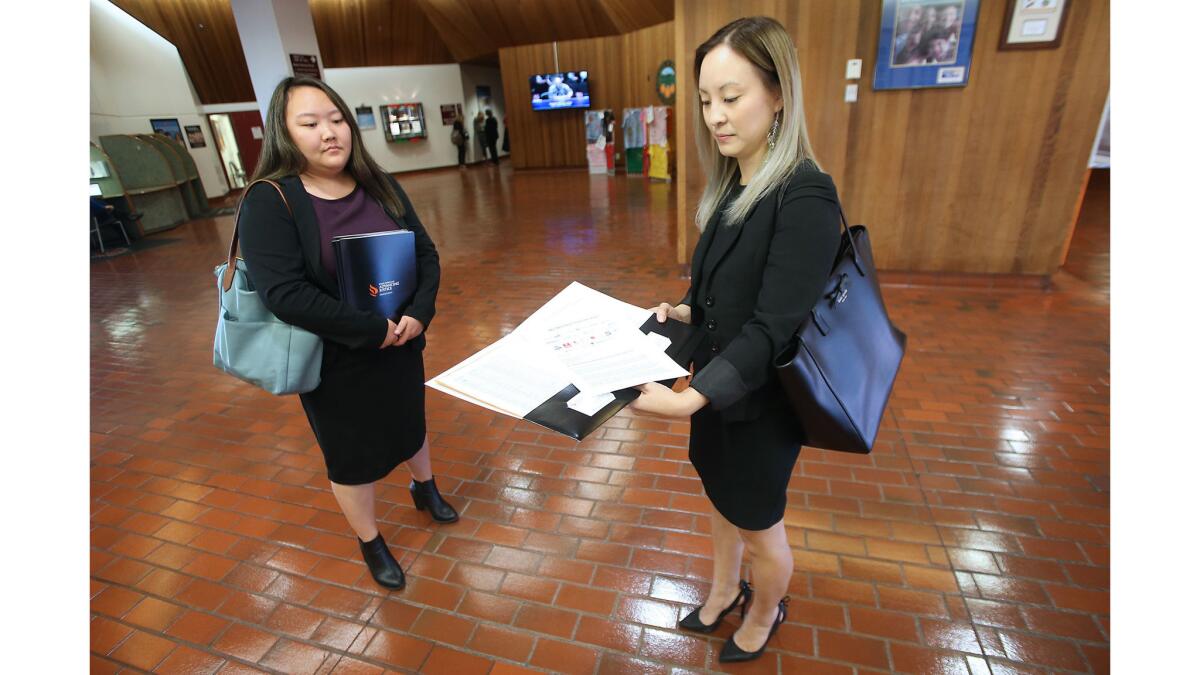 Katelyn Ogawa, left, and Sylvia Kim of Asian Americans Advancing Justice-Orange County attend an Orange County Board of Supervisors meeting in Santa Ana to speak during the public comments session.