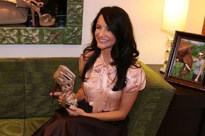 Sex and the City's Kristin Davis holds a pair of Louboutin shoes from the 2011 spring collection in the South Coast Plaza Christian Louboutin shoe boutique.