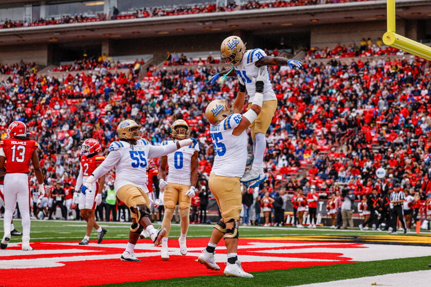 UCLA offensive lineman Hall Schmidt hoists up running back Jaivian Thomas after he scored against Maryland Saturday.