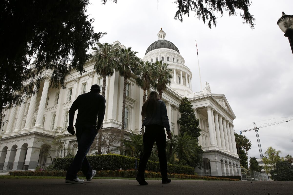 Two people walk near the state Capitol in Sacramento