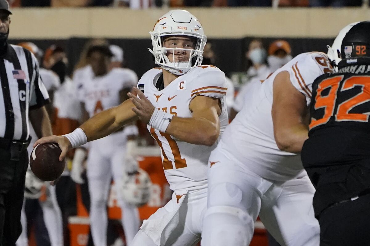 Texas quarterback Sam Ehlinger (11) throws a touchdown pass in overtime of an NCAA college football game against Oklahoma State in Stillwater, Okla., Saturday, Oct. 31, 2020. (AP Photo/Sue Ogrocki)