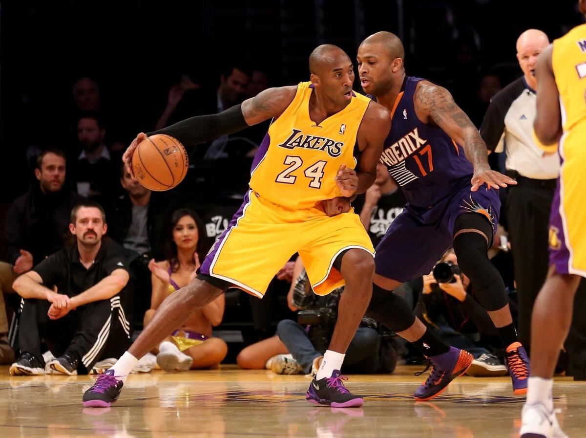 Kobe Bryant backs into Phoenix's P.J. Tucker during the Lakers' 114-108 loss Tuesday to the Suns at Staples Center.