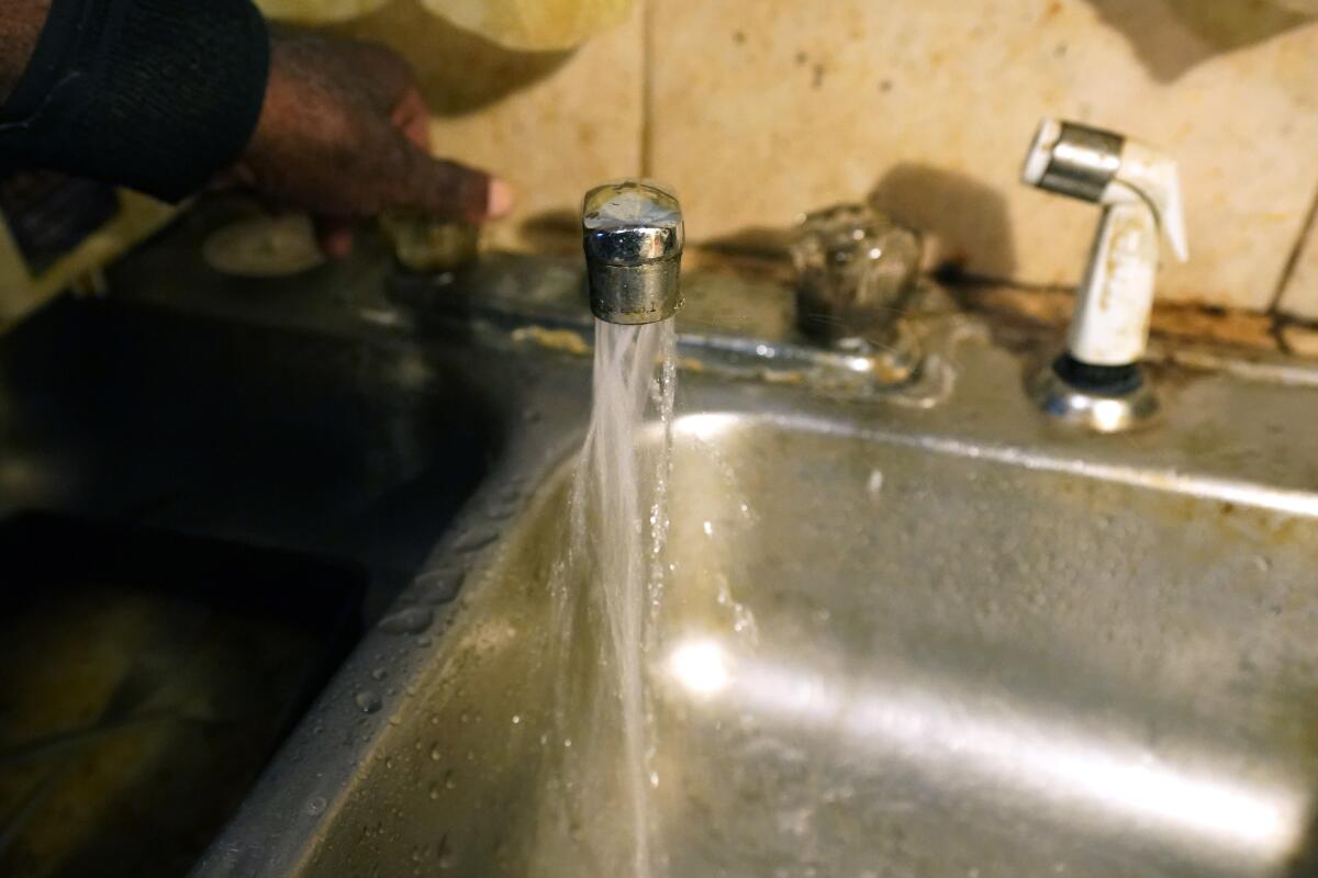 Water flows from a faucet in a home in south Jackson, Miss.
