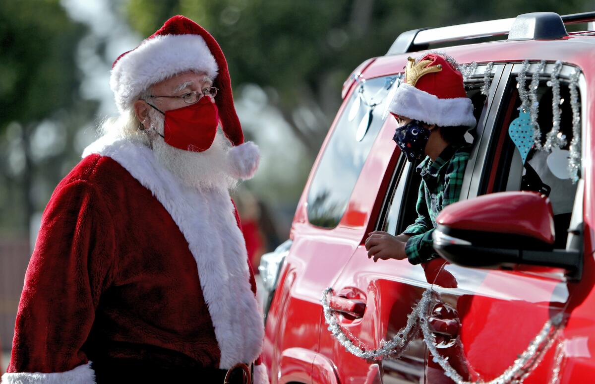 Santa Claus talks to 5-year-old Donovan Karan during a drive-through event at St. Bonaventure Catholic School.