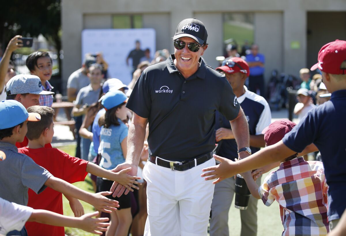 Phil Mickelson greets young golfers in August 2019.