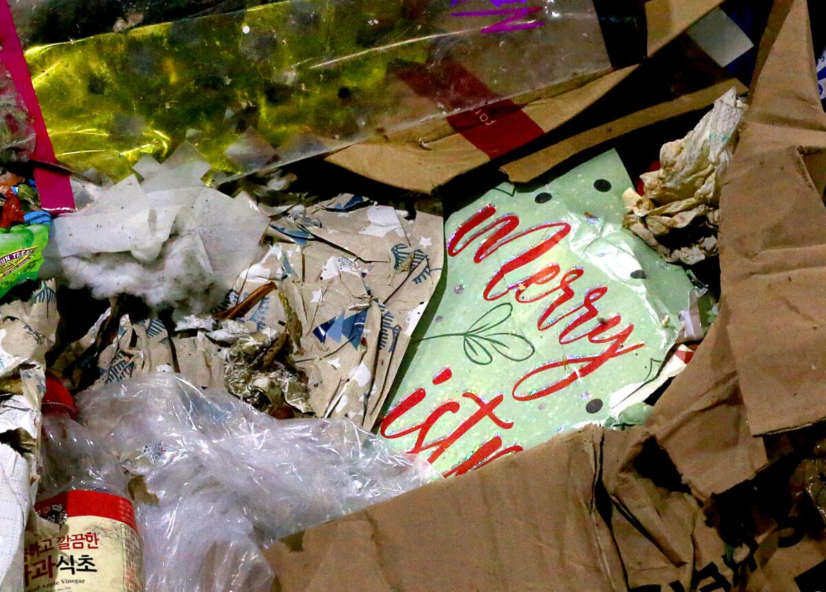 Christmas wrapping and other paper and plastic waste are piled high inside a recycling facility.