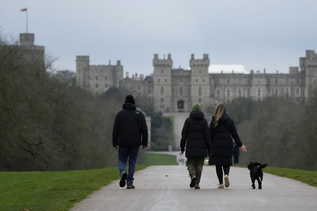 People walk their dogs on the Long Walk at Windsor, England, on Christmas Day, Saturday, Dec. 25, 2021. Britain's Queen Elizabeth II has stayed at Windsor Castle instead of spending Christmas at her Sandringham estate due to the ongoing COVID-19 pandemic. (AP Photo/Alastair Grant)