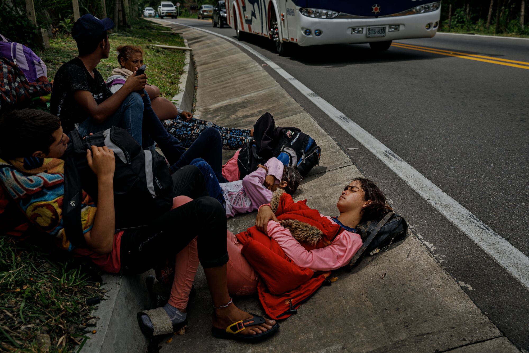 Delimar Fonseca, 18, rests with her family and friends on the side of the Route 55 near Jimenez, Colombia as vehicles speed past.