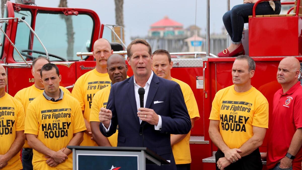 Democrat Harley Rouda appears at Huntington Beach Pier with members of the Orange County Professional Firefighters Assn., which endorsed him in his race against Rep. Dana Rohrabacher.