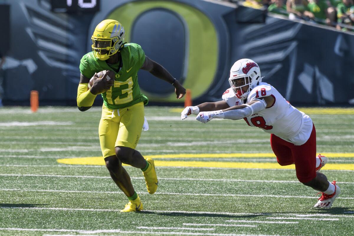Oregon quarterback Anthony Brown eludes Fresno State defensive end Isaiah Johnson on a touchdown run in the fourth quarter.